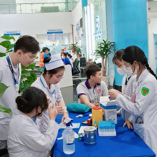 Students receiving hands-on instructions on blood sample collection procedures.